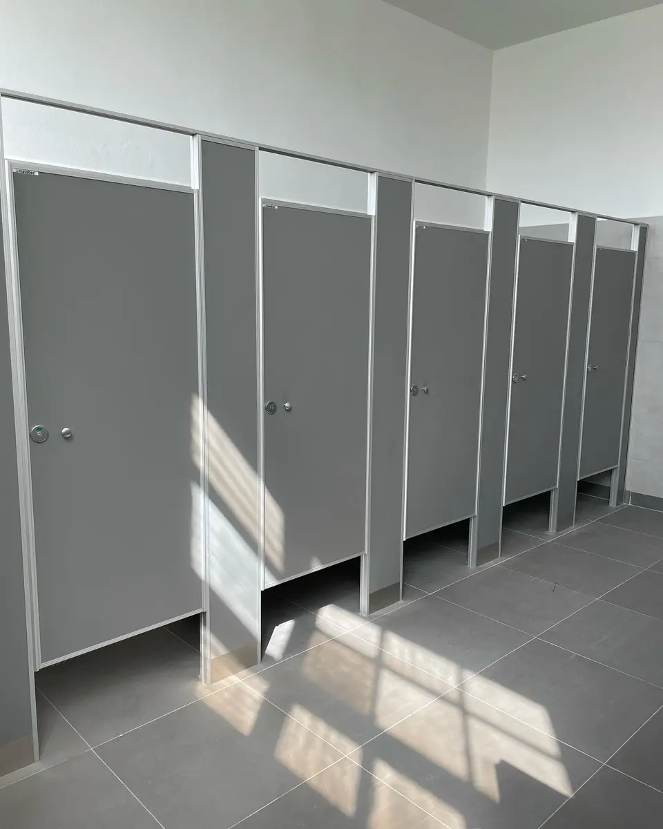 Baños del Taller General de AGP con tabiques sanitarios grises (foto 1 de 7)