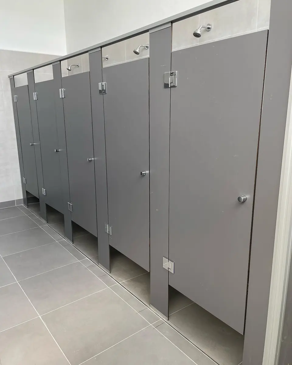 Baños del Taller General de AGP con tabiques sanitarios grises (foto 3 de 7)