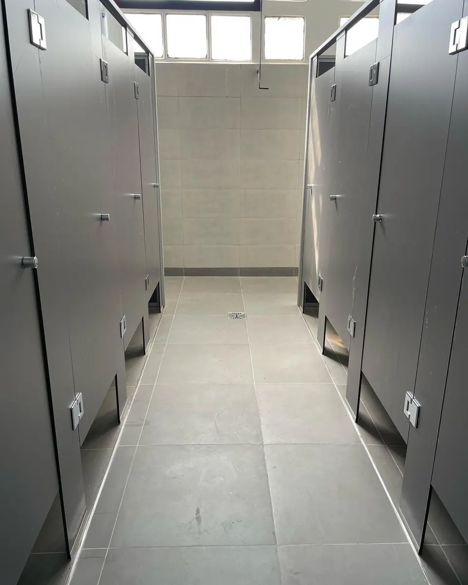 Baños del Taller General de AGP con tabiques sanitarios grises (foto 4 de 7)