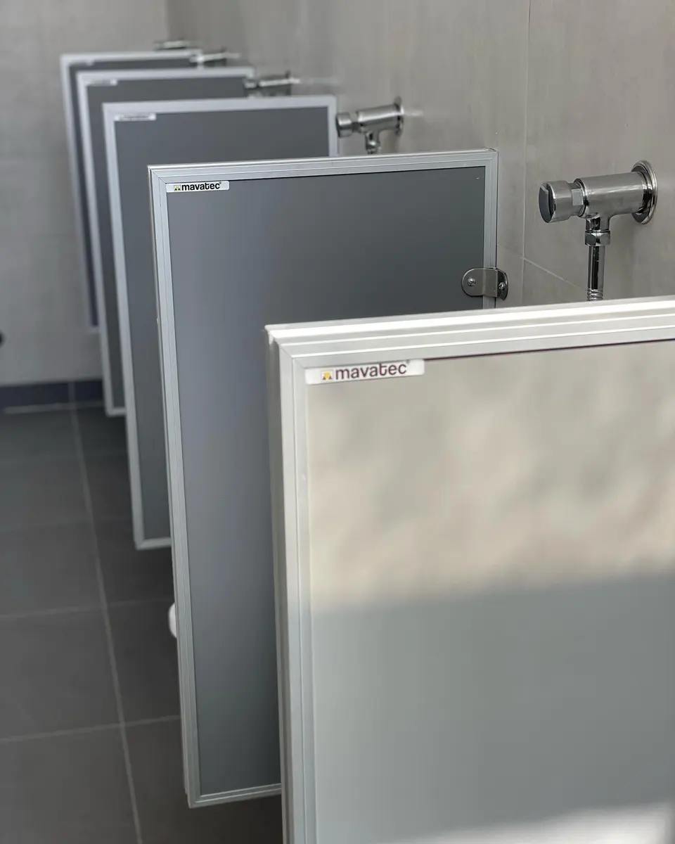 Baños del Taller General de AGP con tabiques sanitarios grises (foto 5 de 7)