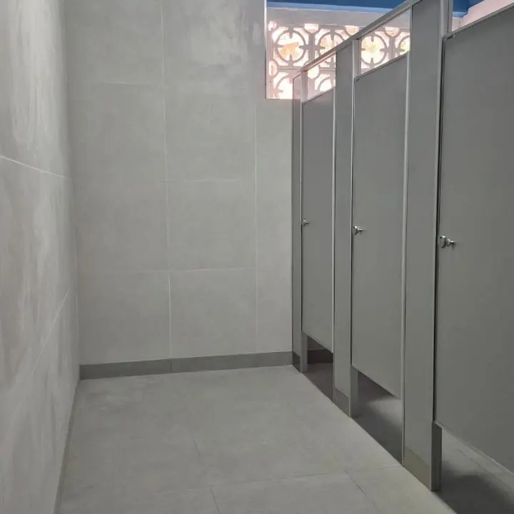 Baños del Colegio Mariano Moreno con tabiques sanitarios gris perla (foto 3 de 6)