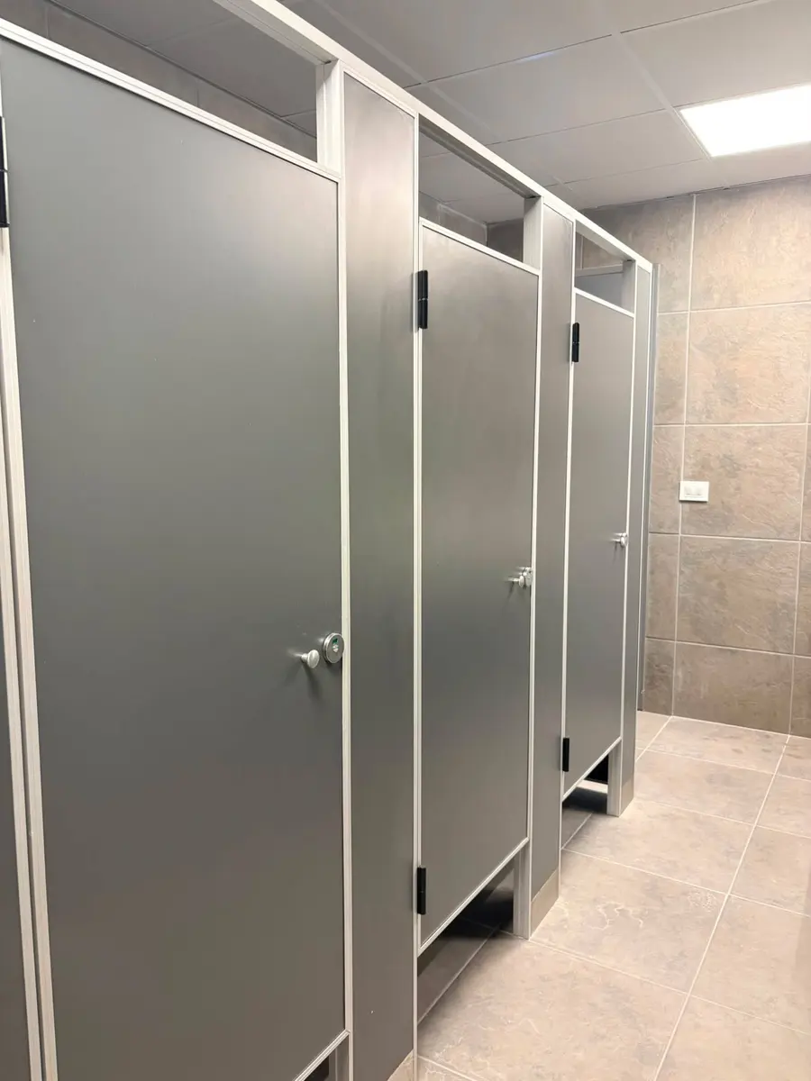 Baños de Conecta Pádel con tabiques sanitarios grises (foto 2 de 2)
