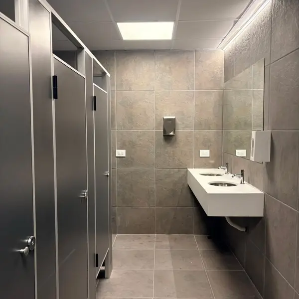 Baños de Conecta Pádel con tabiques sanitarios grises