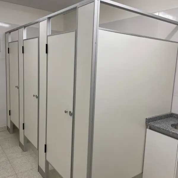 Baños de la Escuela Técnica N.° 8 con tabiques sanitarios blancos