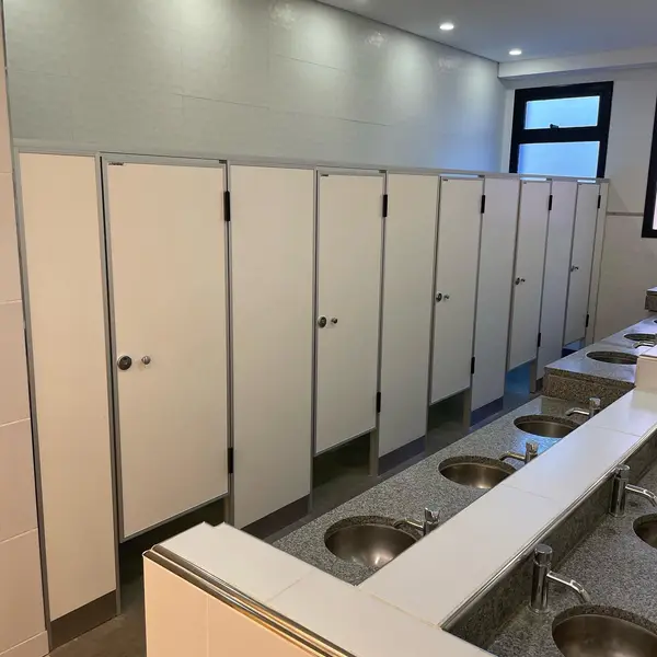 Baños de St. Matthew's College con tabiques sanitarios claros