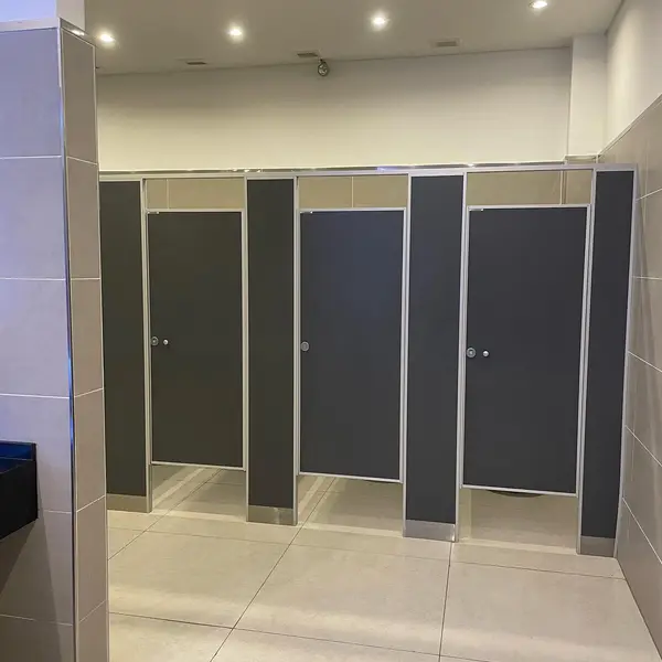 Baños de Trilenium Casino con tabiques sanitarios oscuros