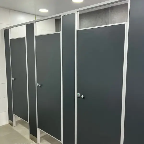 Baños de la estación YPF Brandsen con tabiques sanitarios oscuros
